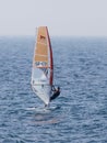 Young athlete in a black tracksuit exercising in windsurfing in the Mediterranean sea in Nahariya, Israel Royalty Free Stock Photo