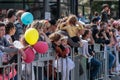 The audience are standing behind the fence and looking at the carnival of Adloyada in Nahariyya, Israel