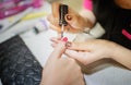 The nail artist is applying nail polish to the customers