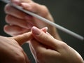 Nail beautician polishing nails