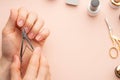 Nail care. Beautiful women hands making nails painted by pink delicate nail polish on a gentle background