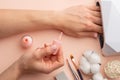 Nail care. Beautiful women hands making nails painted by pink delicate nail polish on a gentle background. Female hands near a set