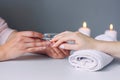 Nail care. Closeup of beautiful woman hands getting manicure in spa salon. Female manicurist cleaning cuticle with