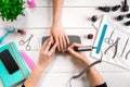 Nail care. Closeup of female hands filing nails with professional nail file in beauty nail salon. Top view Royalty Free Stock Photo