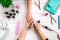 Nail care. Closeup of female hands filing nails with professional nail file in beauty nail salon. Top view Royalty Free Stock Photo