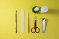 A nail file, scissors, wooden cuticle sticks, nail oil on a yellow background, top view. Royalty Free Stock Photo