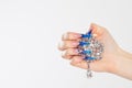 Nail Polish. Art Manicure. Modern style blue Nail Polish. Beauty hands holding white crystals gem stones diamonds broach showing