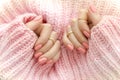 Nail Polish. Art Manicure. Modern style pink Nail Polish.Stylish pastel Color pink Nails holding wool material sleeve