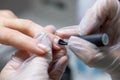 The nail service master does a manicure holds his finger and applies a transparent gel polish to protect the nail Royalty Free Stock Photo