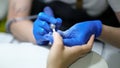 Nail specialist doing manicure to client using special apparatus, hardware manicure