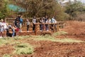 Tourists photograph a warthog while waiting for the elephants to appear for their daily feeding