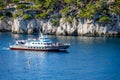 A tour boat sails along the rocks of the National Parc des Calanques. Royalty Free Stock Photo