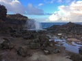 Nakalele Blowhole with water spraying out that was created from Pacific Ocean waves hitting the tall rocky cliff coastline that wa