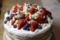 naked cake with a white cream strawberries blueberries and a white chocolate