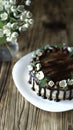 Naked drip cake with chocolate, decorated with strawberries, jasmine flowers and honeysuckle on brown wooden table Royalty Free Stock Photo