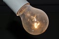 Naked dusty light bulb glows electricity