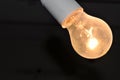 Naked dusty light bulb glows electricity