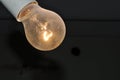 Naked dusty light bulb glows electricity