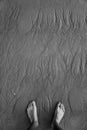 Naked foots on the Sand surface with unusual patterns. Water made pictures on a sand while low tide. Black and white. Royalty Free Stock Photo