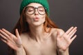 Ginger woman wearing glasses and green hat pouting her lips ready for kiss Royalty Free Stock Photo