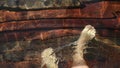 Naked hairy male legs walk on pier. The legs of a man swim. First person of view. Men rest on a flood wood underwater Royalty Free Stock Photo