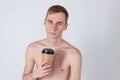 Naked handsome guy drink from coffee or tea cup. Morning refreshment and drink