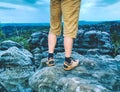 Naked legs of successful hiker on exposed sandstone rock