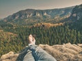 Naked male crossed legs take a rest on rock