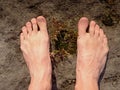 Naked male feet on dry sandstone. Fresh pink skin, shor tnails. Foot on pure nature ground Royalty Free Stock Photo