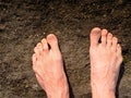 Naked male feet on dry sandstone. Fresh pink skin, shor tnails. Foot on pure nature ground Royalty Free Stock Photo