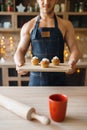 Naked man in apron holds tray with dessert Royalty Free Stock Photo