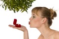 Naked woman kissing a ring under mistletoe