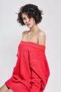 Naked woman with short hair. Girl posing in a red sweater on a white background. Perfect clean skin, Nude body of Royalty Free Stock Photo
