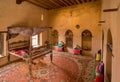 Nakhal, Oman - 04.03.2018: Room of a medieval arabian castle. Carpets and pillow on the floor, holy books on the shelf