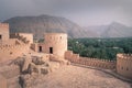 Nakhal,Oman - 04.01.2018: Storm coming to medieval arabian fort of Nakhal, Oman. Walls, palm trees and mountains in a