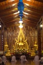 Thai Buddhists are sitting and praying front of ain Buddha inside a Church.