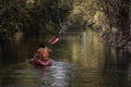 Rear view of young couple Woman and man. Adventurous people having fun together while red kayaking on brook in forest