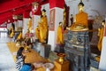 Thai lady prays in front of a Buddha statue at Wat Phra Mahathat Woramahawihan temple in Nakhon Sri Thammarat, Thailand.