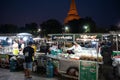 Nakorn Prathom, Thailand - April 4, 2023 : Local people walking in food truck night market in front of Phra Pathom Chedi the