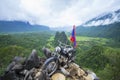 NAM XAY VIEWPOINT, VANG VIENG, LAOS - JULY 25, 2019: Ancient motorcycle parked and Lao flag on the Nam Xay Viewpoint, During the