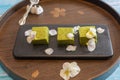 Nama Matcha Chocolate With Edible Flowers on a Traditional Wooden Tray