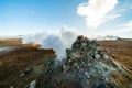 Namafjall Hverir geothermal area in Iceland. Stunning landscape of sulfur valley with smoking fumaroles and blue cloudy Royalty Free Stock Photo