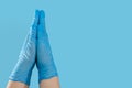 Namaste gesture made by hands in medical gloves. Blue background. Copy of space. Place for text.