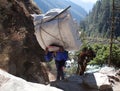 Nepalese porter carrying a heavy load, Nepal Himalayas Royalty Free Stock Photo