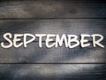 The name of the month is composed of light wooden letters on dark wood. The month of September.