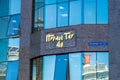 The name of the Nurly Tau business center above the entrance group and the address in the city of Almaty