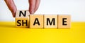 Name or shame symbol. Businessman turns the wooden cube and changes the word `shame` to `name` or vice versa. Beautiful yellow