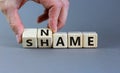 Name or shame symbol. Businessman turns wooden cubes and changes the word `shame` to `name` or vice versa. Beautiful grey