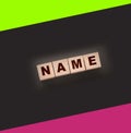 Name word with wooden block on black blackboard. Business or personal brand concept
