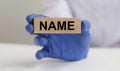 NAME word on wooden block in doctor hand